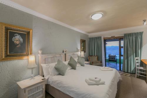 a bedroom with a large white bed and a window at Villa Castollini in Brenton-on-Sea
