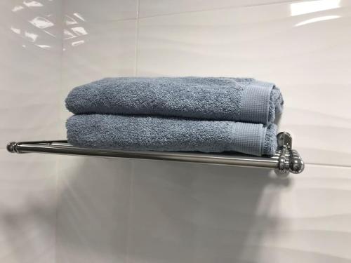 a pile of towels on a towel rack in a bathroom at Calpe Beach Boutique Luxury Seaview Suite in Calpe