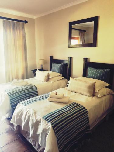 two beds sitting next to each other in a room at Ash River Lodge in Clarens
