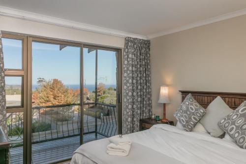 a bedroom with a bed and a large window at Villa Castollini in Brenton-on-Sea
