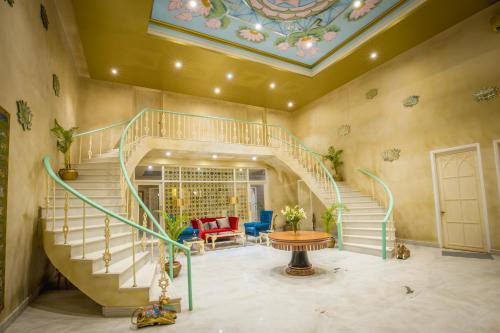 a living room with a spiral staircase with a table at Rose Amer in Jaipur