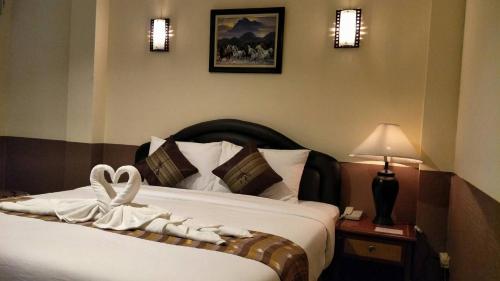 バンコクにあるBaik Suiteのホテルルーム ベッド1台(リボン付)