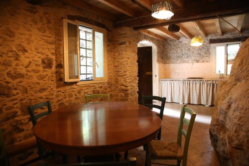 a dining room with a wooden table and chairs at A Cà Du Barbijun in Pieve di Teco