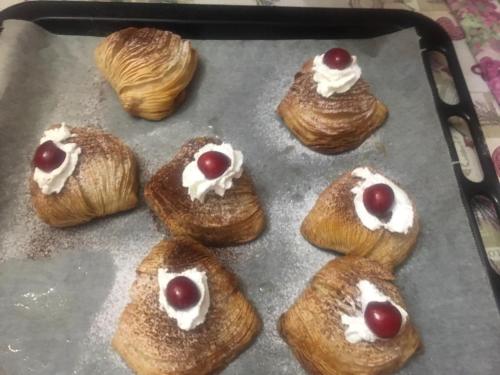 a tray of pastries with cherries and whipped cream at B & B Evergreen in Corbara