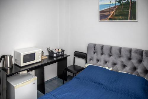 1 dormitorio con 1 cama y escritorio con microondas en Vilnius Centre Flat, en Vilna