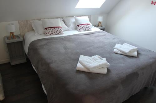 a bedroom with a large bed with towels on it at ENTRE LOIRE ET CHER Gîte "Le Nid Douillet" in Tour-en-Sologne