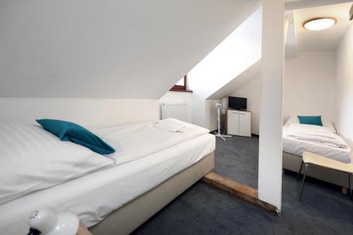 a bedroom with two beds with blue pillows at Pension U Tří sedláků in České Budějovice