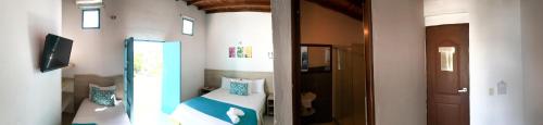 een kleine slaapkamer met een bed en een hal bij Hotel Aldea Plaza in Doradal