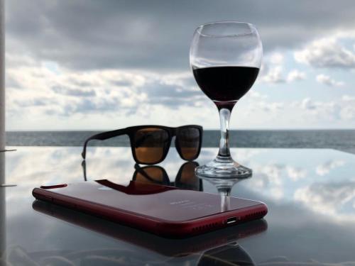 a pair of glasses and a glass of wine on a table at My Batumi Apartments in Batumi