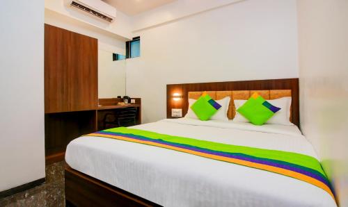 a bedroom with a large white bed with colorful pillows at Treebo Arvind Residency in Mumbai