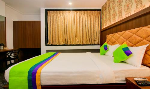 a bedroom with a large bed with a colorful blanket at Treebo Arvind Residency in Mumbai