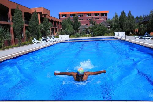 a man laying in a swimming pool at Yaya Africa Athletics Village in Sululta