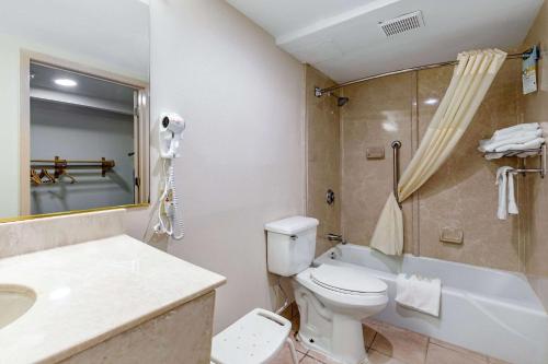 a bathroom with a toilet and a sink and a tub at Quality Inn Tyler - Lindale in Tyler