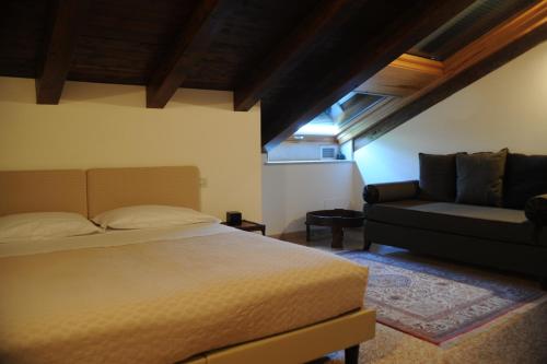 ボローニャにあるAl Melograno - Room & Breakfastのベッドルーム(ベッド1台、ソファ付)