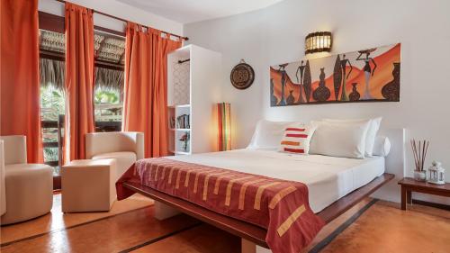 un dormitorio con una cama y una silla en Araxá Pousada, en Jericoacoara