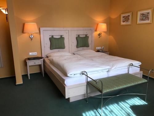 a bedroom with a large white bed and two lamps at Gasthaus Beinker in Ostercappeln