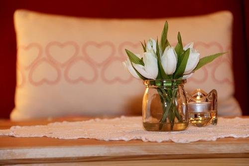 a vase with white flowers sitting on a table at Ferienwohnungen Haus Marlene Kaiser in Bernau im Schwarzwald