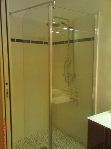 une douche en verre dans une salle de bain avec un lavabo dans l'établissement Triplex entre ciel et mer, à Roquebrune-Cap-Martin