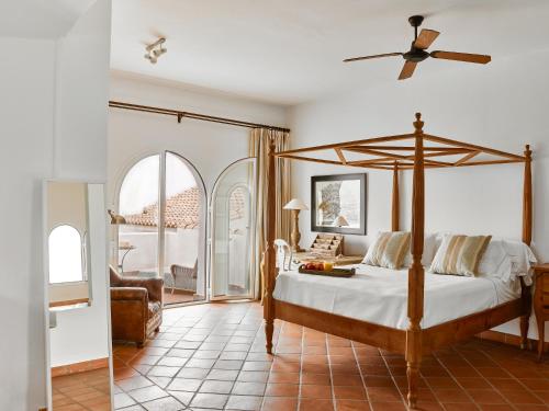 1 dormitorio con 1 cama y ventilador de techo en B Bou Hotel Cortijo Bravo, en Vélez-Málaga