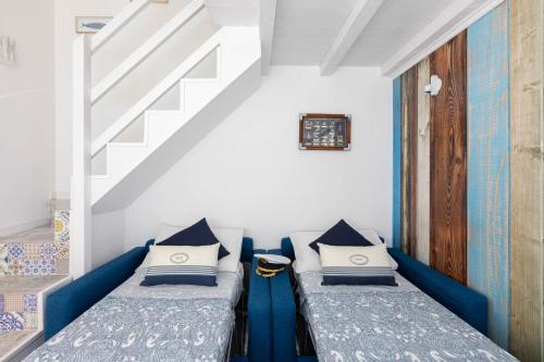 two beds in a room with a staircase at Sea Elegance in Oliveri