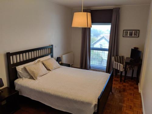 een slaapkamer met een groot bed en een raam bij Apartamento em Monsanto - Porto in Porto