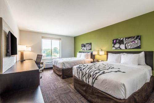 a hotel room with two beds and a flat screen tv at Sleep Inn Ellenboro Hwy 50 in Ellenboro