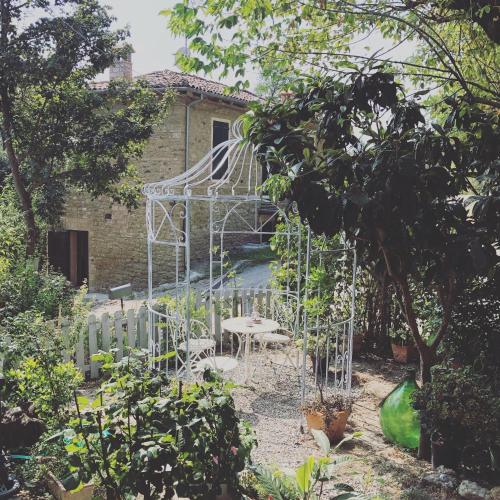 a garden with a metal gate and tables and chairs at B&B Agriturismo Casa Vallona in Monte San Pietro
