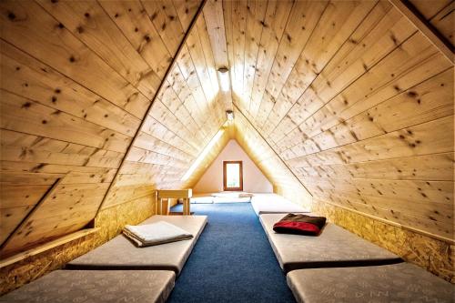 a room with two beds in a wooden room at Ťatliakova chata in Zuberec