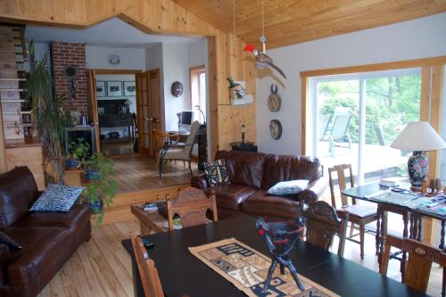 sala de estar con sofá y mesa en Gîte au Pied du Courant de Gilbert Desjardins, en Mont-Laurier