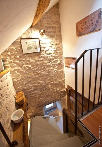 Un escalier mène à une chambre dotée d'un mur en pierre. dans l'établissement La Petite Sentence de Noyers, à Noyers-sur-Serein