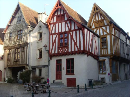 Un edificio antiguo con rojo y blanco. en La Petite Sentence de Noyers, en Noyers-sur-Serein