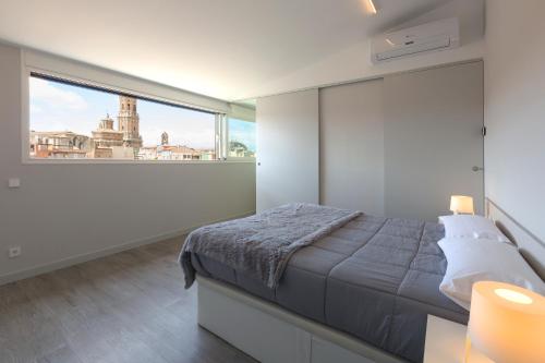 a bedroom with a bed and a large window at APARTAMENTOS TURISTICOS - PAPEL ARMADO - Calle Caldereros 33 in Tudela