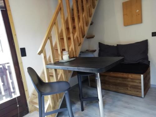 a table and a chair in a room with stairs at Studio en Duplex Renové in Thônes
