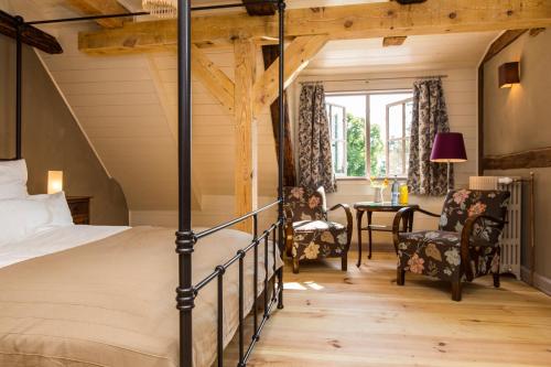 a bedroom with a bed and a table and chairs at Gutshaus Lexow in Lexow