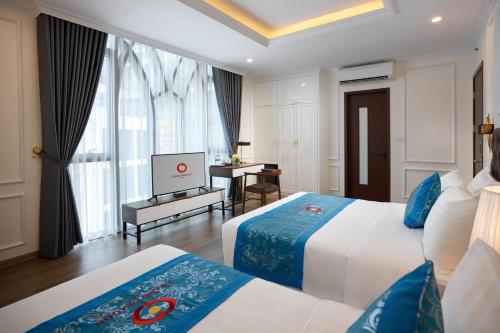 Postel nebo postele na pokoji v ubytování Grand Dragon Hotel Hanoi