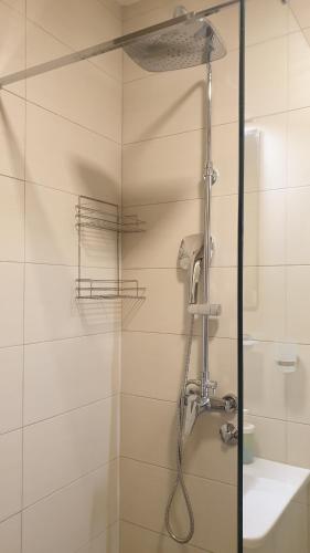y baño con ducha con cabezal de ducha. en APARTMENTS TOMIĆ en Bečići