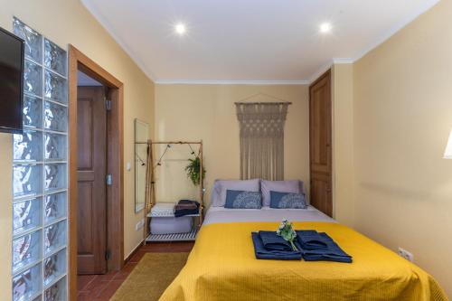 a bedroom with a bed with a yellow blanket at Wine Inn Rustic in Sintra