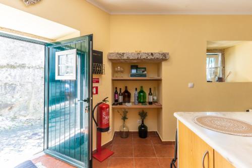 una puerta de cristal que conduce a una cocina con bodega en Wine Inn Rustic, en Sintra