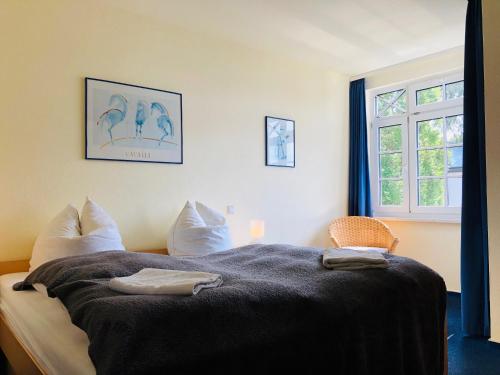 ein Schlafzimmer mit einem Bett mit einer Decke und einem Fenster in der Unterkunft Villa Sanddorn in Binz