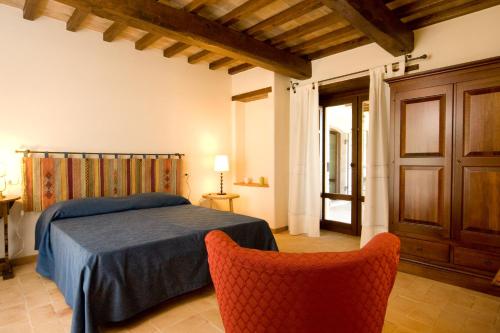Lugnano in TeverinaにあるPoggio del Bologninoのベッドルーム1室(ベッド1台、オレンジ色の椅子2脚付)