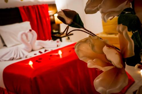 a bedroom with a bed with a red table with candles at Hotel Kahvé in Garzón