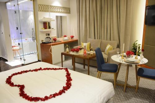 ein Hotelzimmer mit einem Bett und einem Esszimmer in der Unterkunft E1 Hotel in Al Kharj