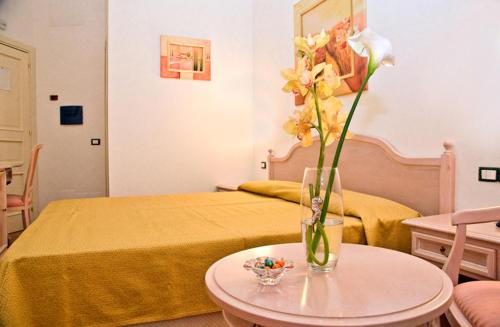 a bedroom with a bed and a vase with flowers on a table at Luna e stelle in Sangineto