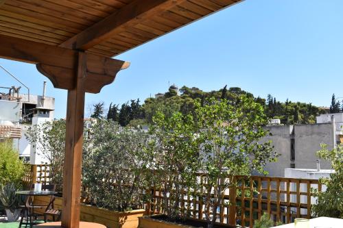 a patio with a wooden pergola and trees at Be My Guest Athens in Athens