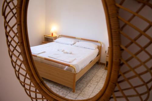 een slaapkamer met een bed in een spiegel bij Casa Gelso in Punta Prosciutto