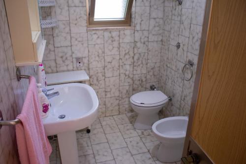 een badkamer met een wastafel en een toilet bij Casa Gelso in Punta Prosciutto