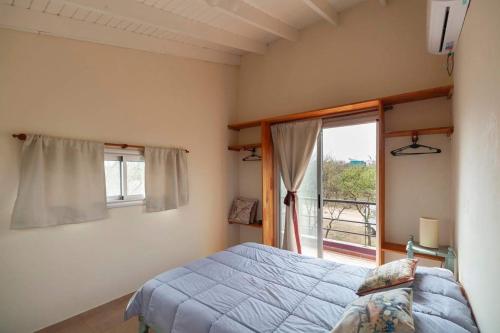 a bedroom with a bed and a large window at Cabaña Anita in Merlo