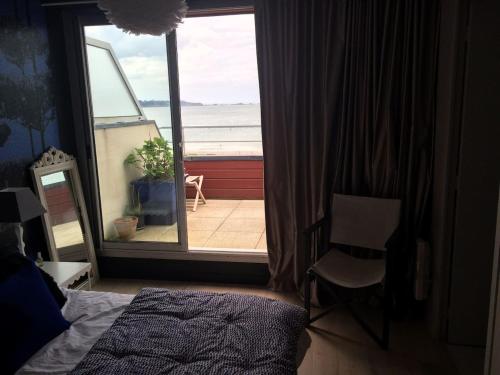 - une chambre dotée d'une fenêtre offrant une vue sur l'océan dans l'établissement Petit havre de paix Face à la mer, à Lancieux