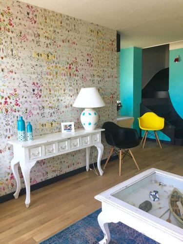 Cette chambre comprend une table blanche et une chaise jaune. dans l'établissement Petit havre de paix Face à la mer, à Lancieux