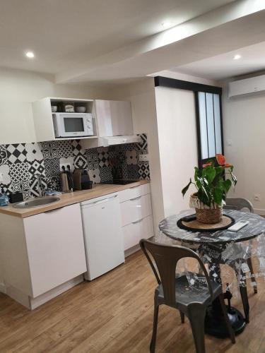 d'une cuisine avec des placards blancs et une table avec une plante. dans l'établissement U STUDIU 7 rue Notre Dame, à Bastia